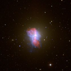 This composite image shows M84, a massive elliptical galaxy in the Virgo Cluster, about 55 million light years from Earth. Hot gas around M84 is shown in a Chandra X-ray Observatory image in blue and a radio image from the Very Large Array is shown in red. A background image from the Sloan Digital Sky Survey is shown in yellow and white.  A number of bubbles are visible in the hot gas, outlined with blue X-ray emission. These bubbles were blown by relativistic particles generated by the central supermassive black hole in M84. These particles travel outwards in the form of a two-sided jet. Because smaller bubbles are found inside large bubbles, the impression given by the image is that of Russian dolls, where smaller dolls can be found inside large ones. These nested bubbles provide clear evidence for repeated outbursts from the central black hole. (Credit: X-ray (NASA/CXC/MPE/A.Finoguenov et al.); Radio (NSF/NRAO/VLA/ESO/R.A.Laing et al); Optical (SDSS))
