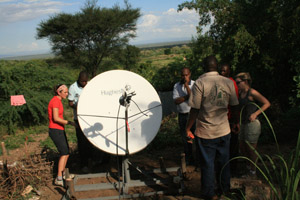 Recent U-M graduate Joan Ervin and Teddy Chenya adjust the satellite dish they helped to install to bring the Internet to rural Kenya.  (Photo: Job Mainye.)