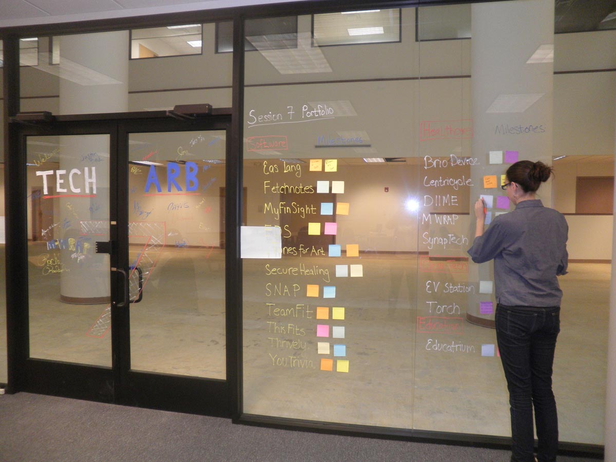 A record number of student-run companies is sharing space in the University of Michigan's TechArb business accelerator. Gillian Henker, with the company DIIME, puts a note on the incubator window. Photo courtesy of Malvika Bhatia