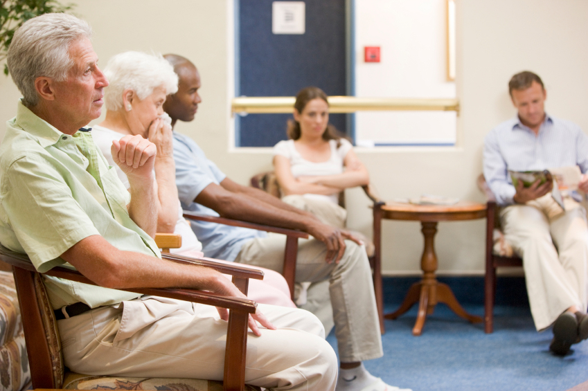 Several people wait in a doctor's office reception area