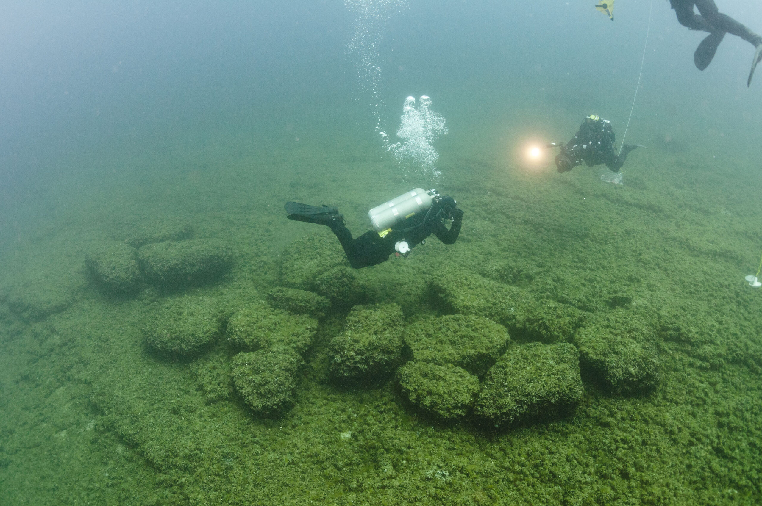 Divers examining boulders at the bottom of Lake Huron that served as caribou drive lanes for prehistoric hunters. Photo courtesy of Tane Casserly