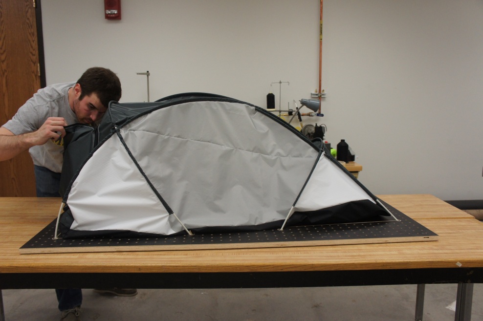 Andrew McCarthy puts the finishing touches on a half-scale model of a  tent he designed for his climbing expedition. Image credit: Andrew McCarthy