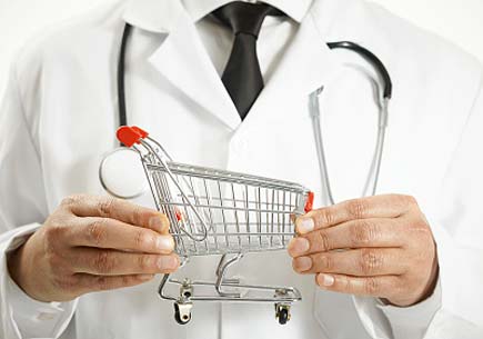 Image depicting physician holding miniature shopping cart (stock)