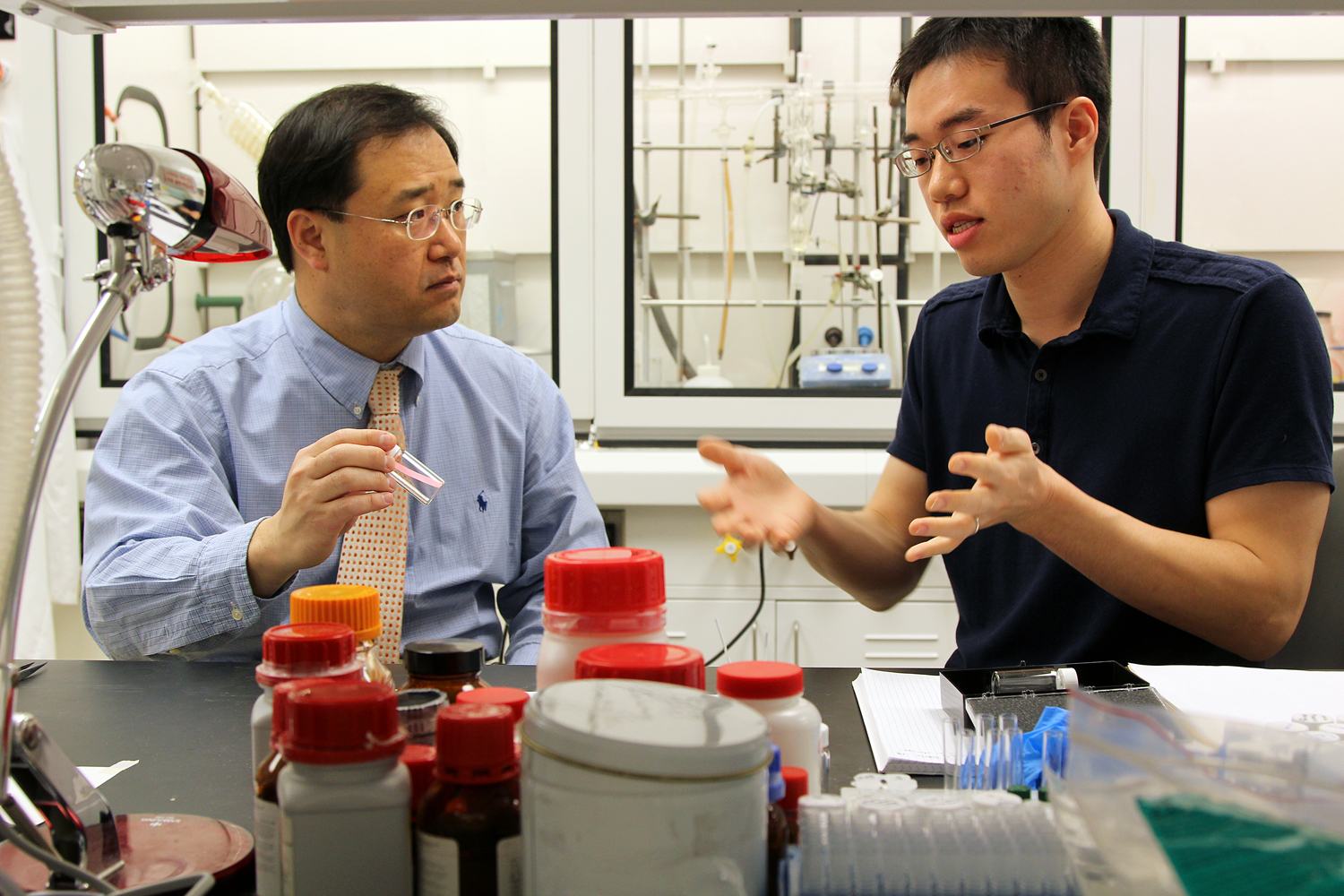 Sungbaek Seo (right), a doctoral student in the program in Macromolecular Science and Engineering and Michigan Engineering Professor Jinsang Kim discuss Nerve Agent Detection at Kim's lab in the NCRC building on UM North Campus. Image credit: Marcin Szczepanski/University of Michigan, COE Multimedia Producer