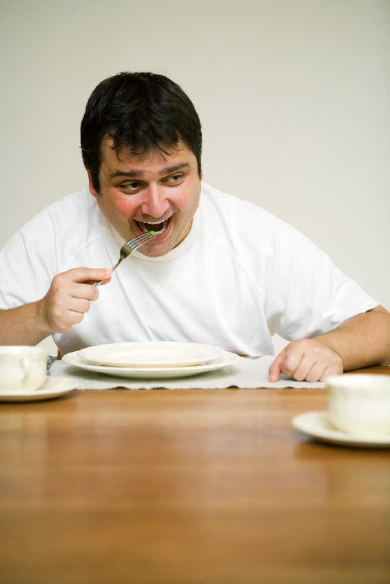 Unconvinced man with a green pea for lunch. (stock image)