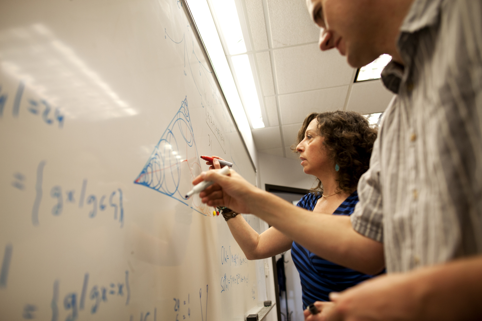 Joshua Anderson (left) and Sharon Glotzer, members of The Glotzer Group in the Laboratory for Computational Nanoscience & Soft Matter, demonstrate their new mathematical problem: the best way to fill a space with overlapping shapes while respecting the boundary. Image credit: Joseph Xu, College of Engineering