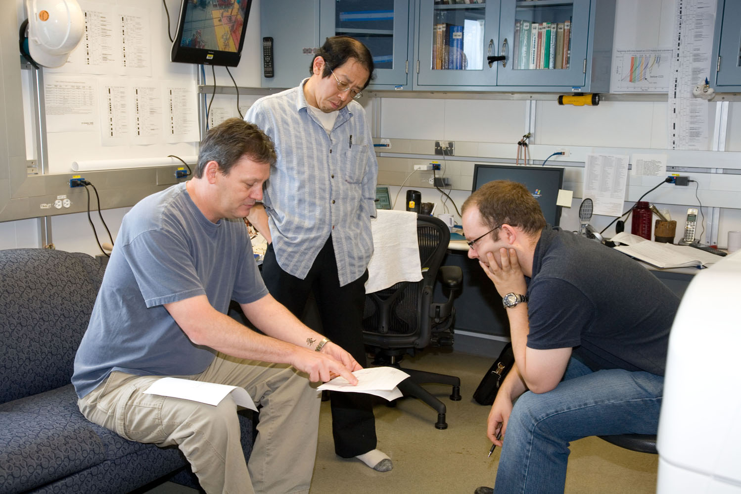 Carl Richter (University of Louisiana, USA) shares data with Co-Chief Scientists Hiroshi Nishi (Hokkaido University, Japan) and Heiko Palike (University of Bremen, Germany). Image credit: Integrated Ocean Drilling Program/United Stated Implementing Organization (IODP/USIO)