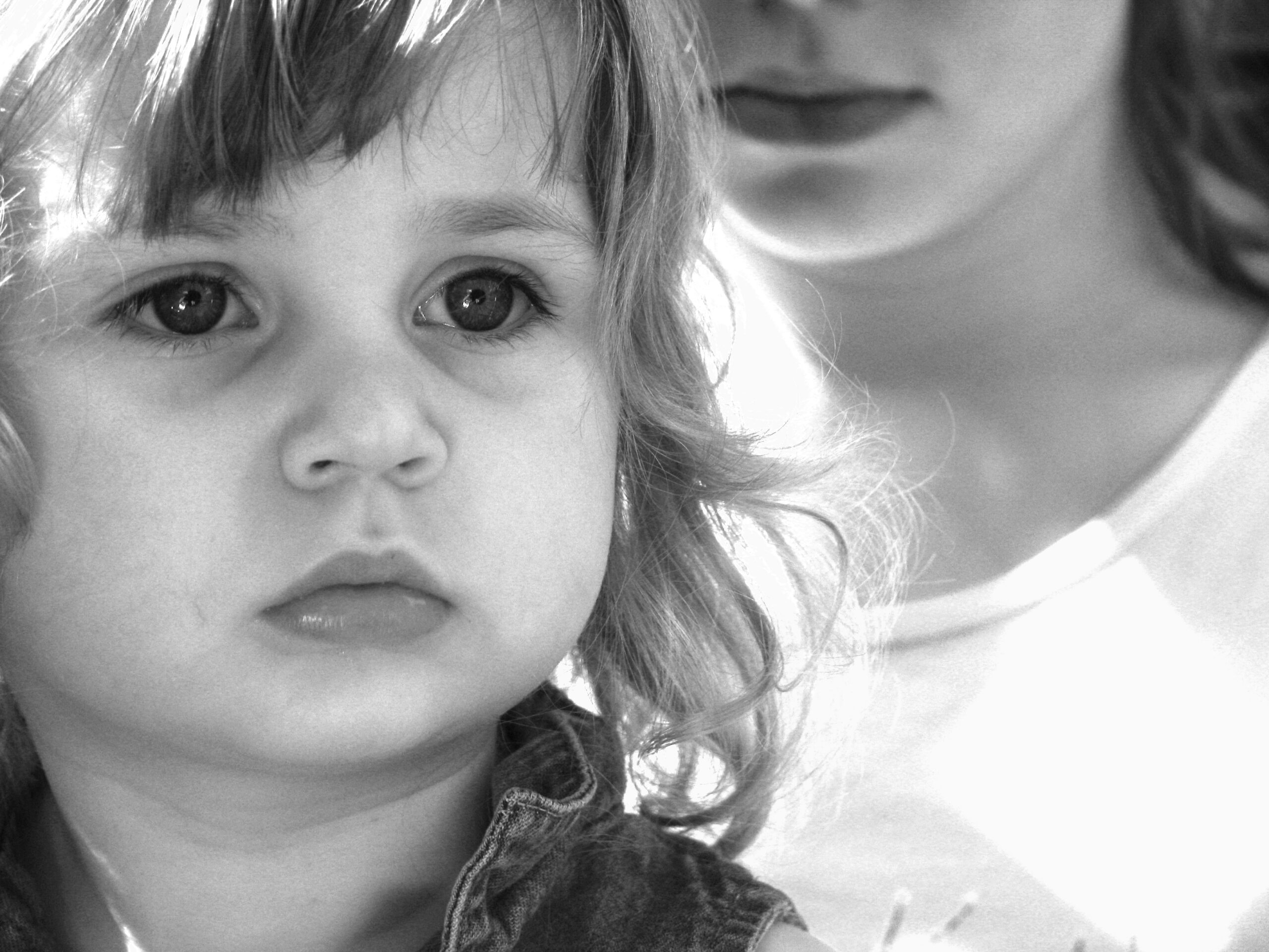 Closeup black and white photo of a sad young girl. Image credit: morguefile.com user anitapatterson