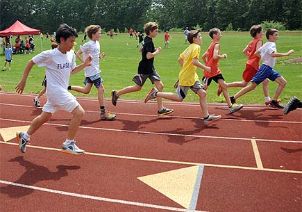 Several young athletes race around a track. Image credit: flickr.com user EaglebrookSchool