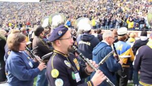 Older alumni perform with the Michigan Marching Band during homecoming weekend.