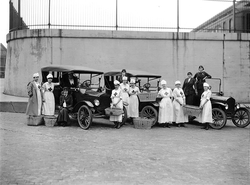 Motor Corps and Canteen volunteers from the Detroit chapter of the American Red Cross, taking a break from delivering supplies to influenza victims. Image courtesy of the National Archives and Records Administration and the Influenza Archives