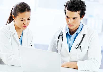 Young doctors working together, they are using a laptop. (stock image)