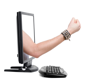  Aggressive fist with spike wristband coming out of computer monitor. (stock image)