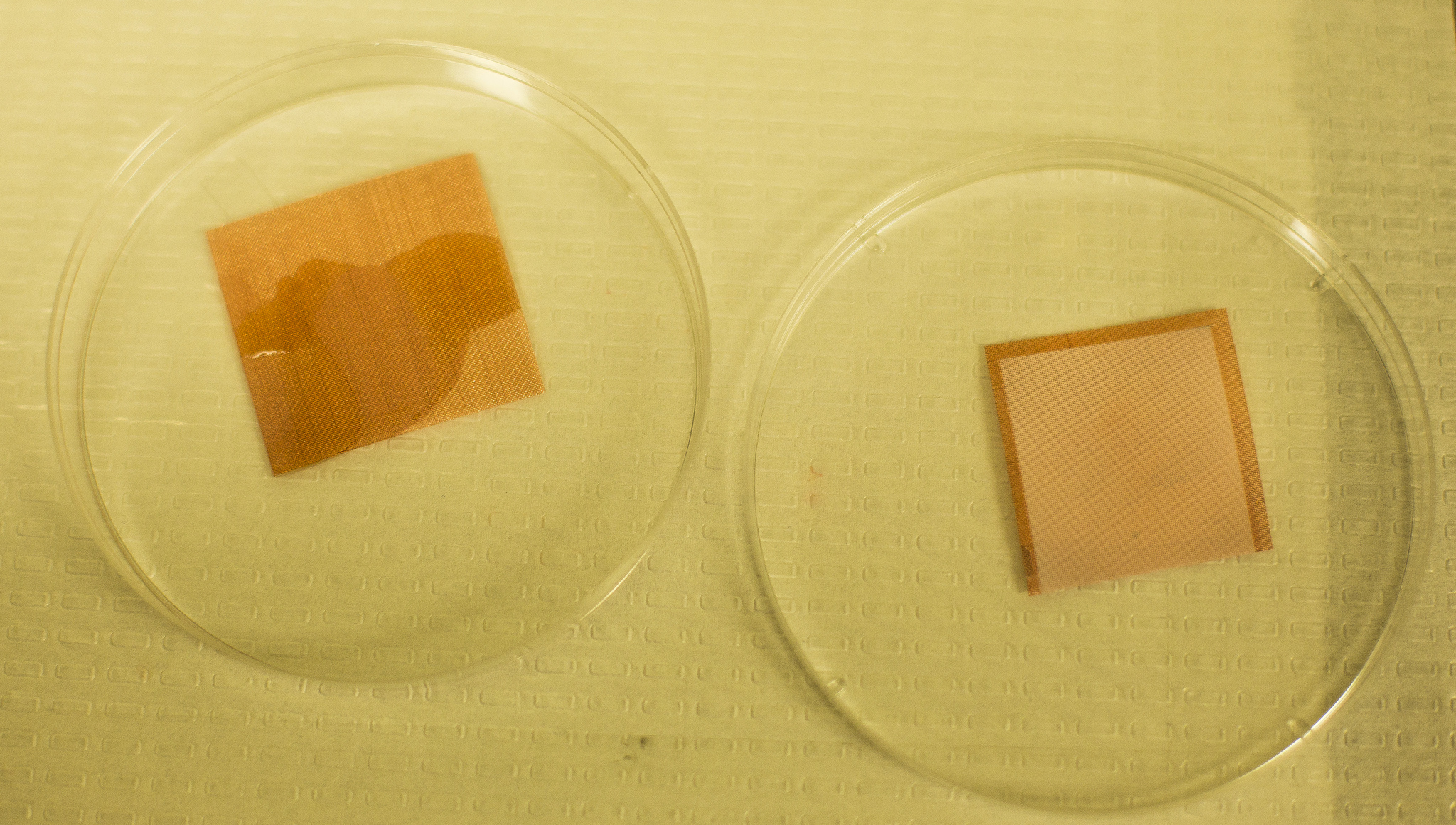 An uncoated tile of screen is wetted by liquids, but a treated piece remains dry. University of Michigan researchers have developed a "superomniphobic" surface that can repel virtually any liquid. Image credit: Joseph Xu, Michigan Engineering Communications & Marketing