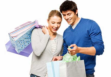 A man and woman happily holding and looking into shopping bags. (stock image)