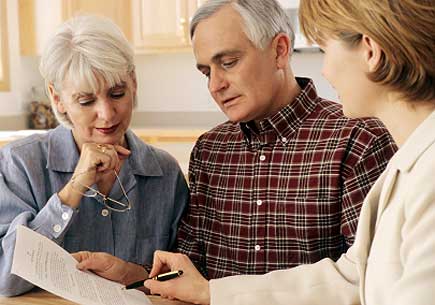 Mature couple talking to financial planner at home (stock image)