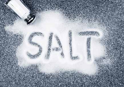 Salt written on counter in spilled salts from shaker. (stock image)