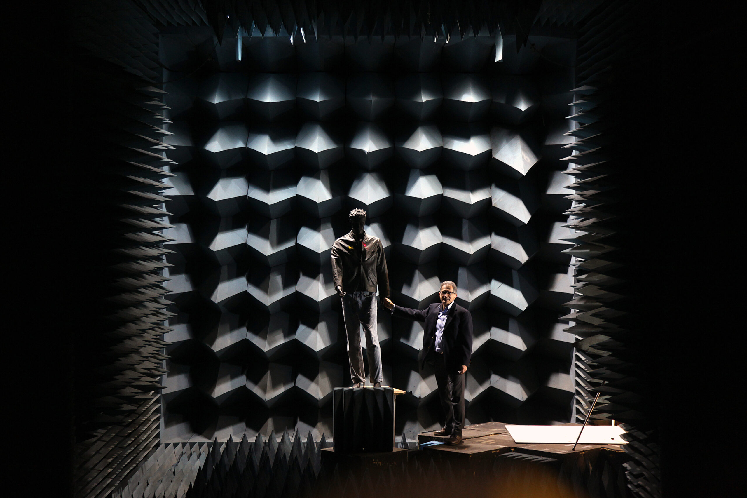 Professor Kamal Sarabandi approaches a mannequin he uses to test his weapons-detecting radar system in an anechoic chamber. His technology could potentially identify a hidden gun or bomb on an approaching person from the distance of a football field away in less than a second. The red dot on the mannequin shows the center of the radar beam, but it can gather information about objects hidden on the subject's torso. Photo by Marcin Szczepanski/Multimedia Producer, University of Michigan, College of Engineering