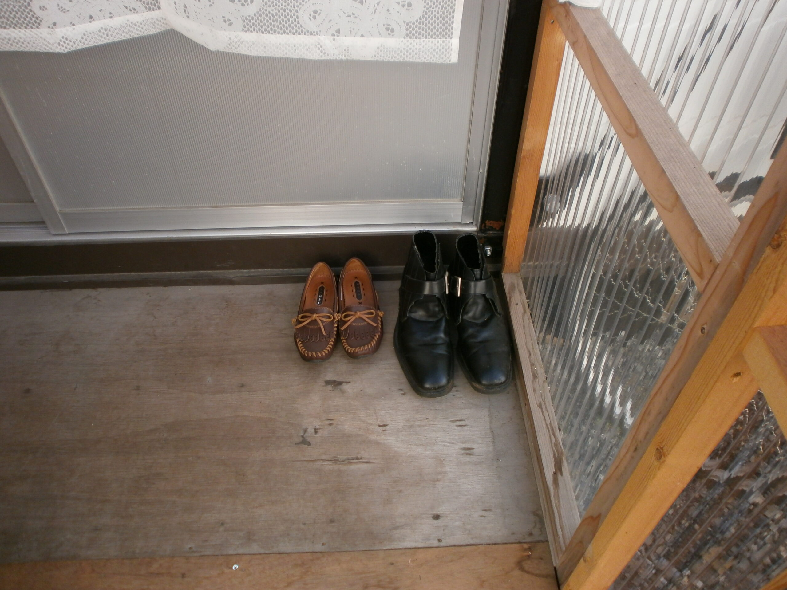 A large pair of men's shoes beside a smaller ladies pair of shoes near front door. Image credit: William Foreman