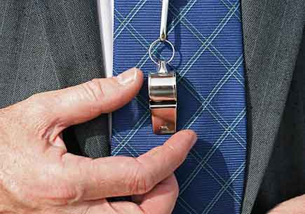 Businessman's' shirt and suit lapels shown with his hand on a silver whistle resting on the tie (stock image)