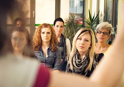 A group of professional women listening to a speaker. (stock image)