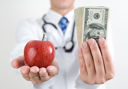 Doctor holding an apple and money