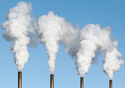 Photo of thick white smoke billowing from four smokestacks. (stock image)