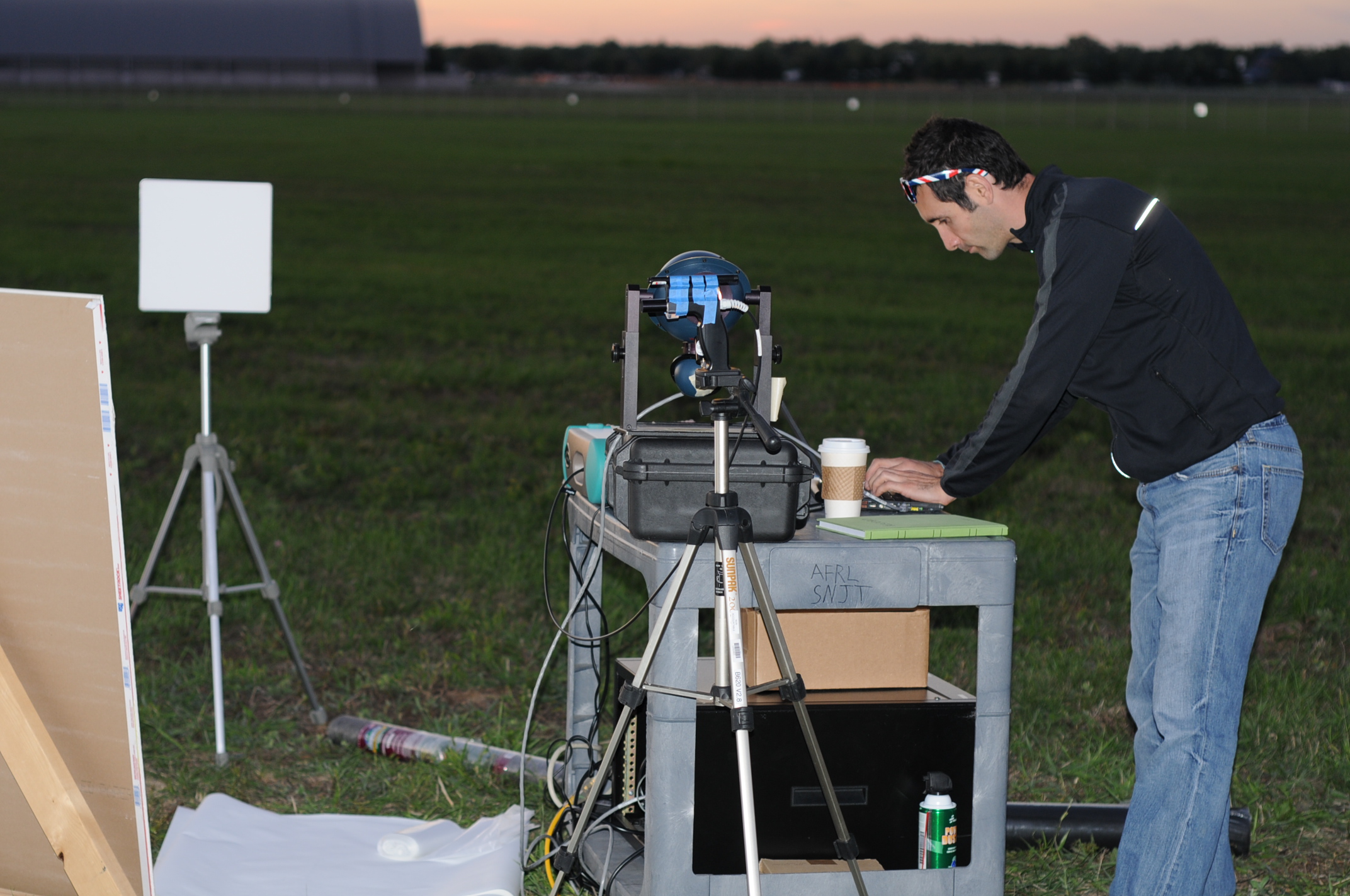 Joseph Meola of Air Force Research Labs conducting measurements on laser light bounced back from various samples placed 1.6 kilometers on the ground from a prototype laser at Wright Patterson Air Force Base. Image credit: Anthony Absi, Air Force Research Labs