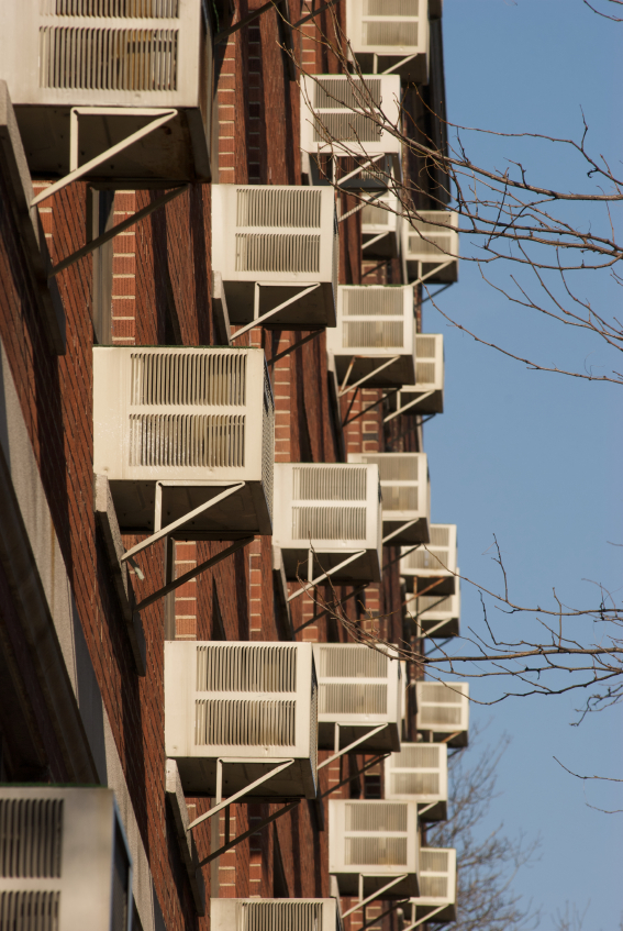 Building in the city with several window air conditioners. (stock image)