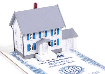 Miniature house on a mortgage bond. (stock image)