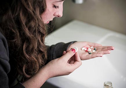  Teen girl holding a selection of pill