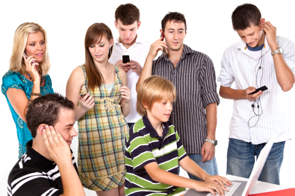 A group of busy teens on the phone and computer. (stock image)