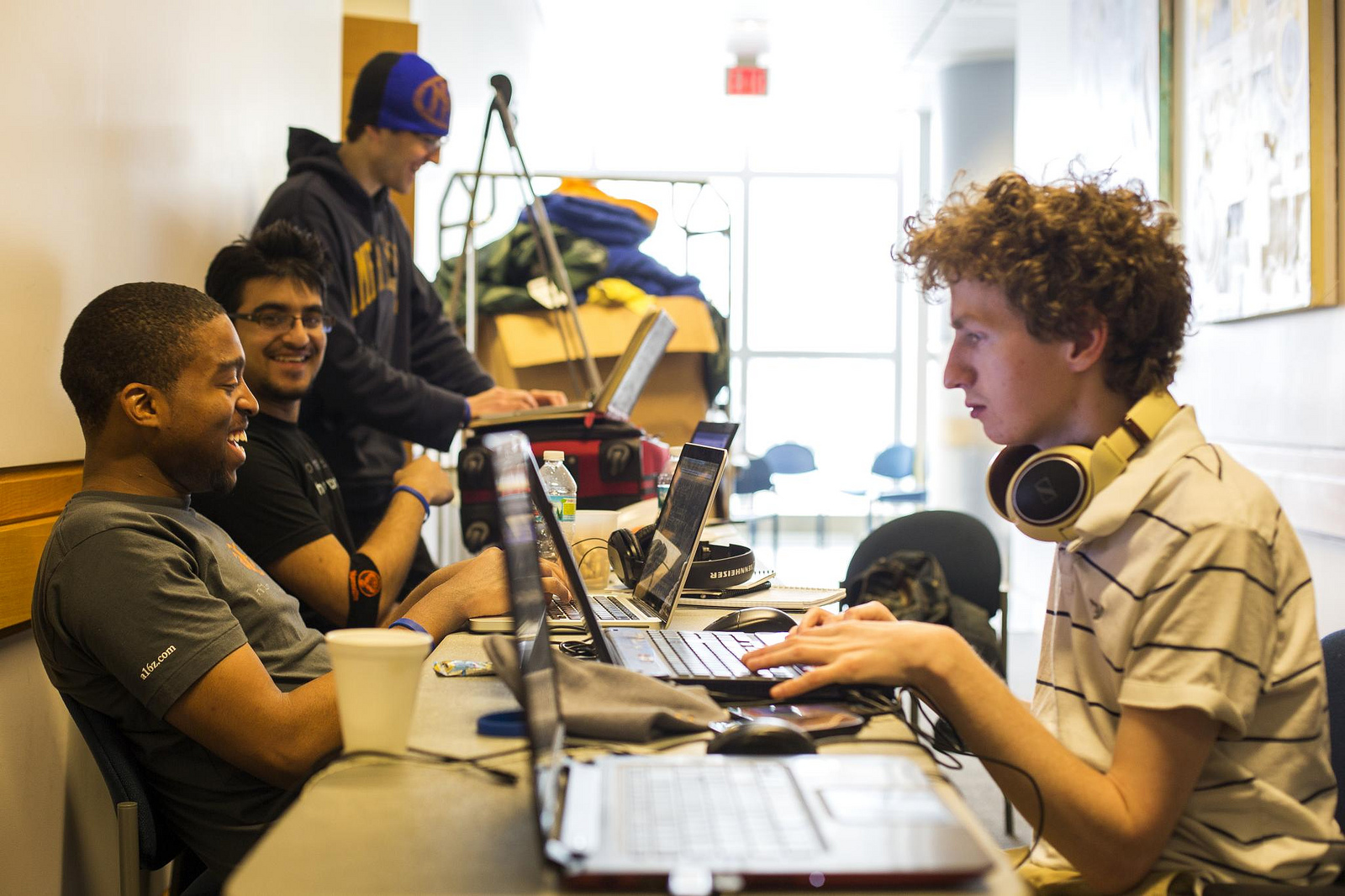 Alexander Biggs (right), of the University of Toronto, and Rashad Russel and Miker Angalz, of the University of Illinois-Urbana Champaign, work in a hallway in the Palmer Commons during the hackathon. Image Credit: Joseph Xu