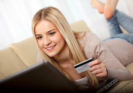 Young woman holding a credit card and using a laptop computer. (stock image)