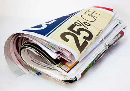 A rolled bundle of newspaper sale ads. (stock image)