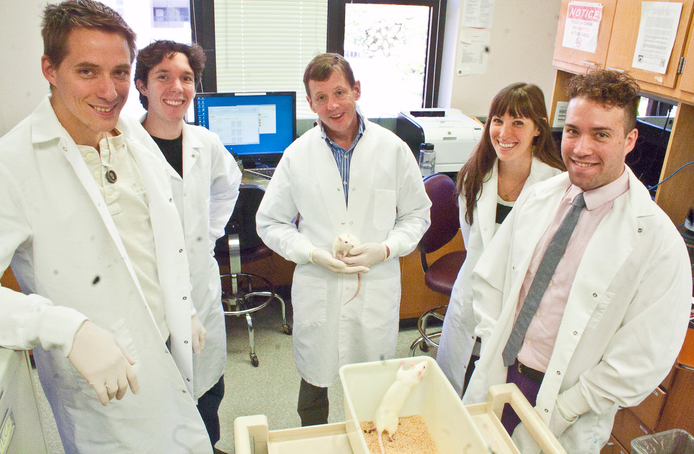 Kent Berridge (center), the James Olds Collegiate Professor of Psychology and Neuroscience, is surrounded by his lab colleagues who study how brain systems generate intense cravings and pleasures in rats and mice. Their work will be highlighted in Berridge's presentation to the Dalai Lama this month in India. From left to right, Mike Robinson, senior postdoctoral fellow; Shannon Cole, doctoral student; Berridge; Shelley Cole, doctoral student; and Daniel Castro, doctoral student. Image credit: Jared Wadley
