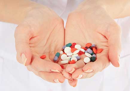 Cupped hands holding various prescription pills. (stock image)