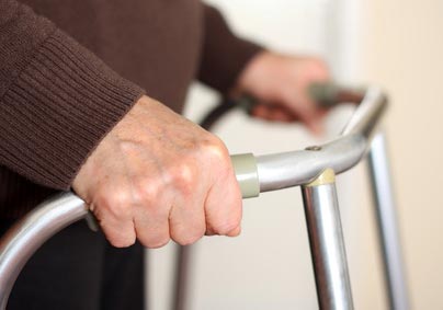 Close-up image of a senior citizen's hands on a walker. Image credit: Flickr.com user SalFalko