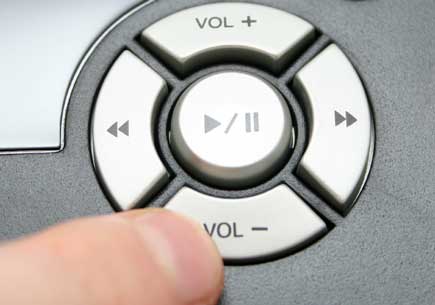 A finger presses the lower volume button. (stock image)