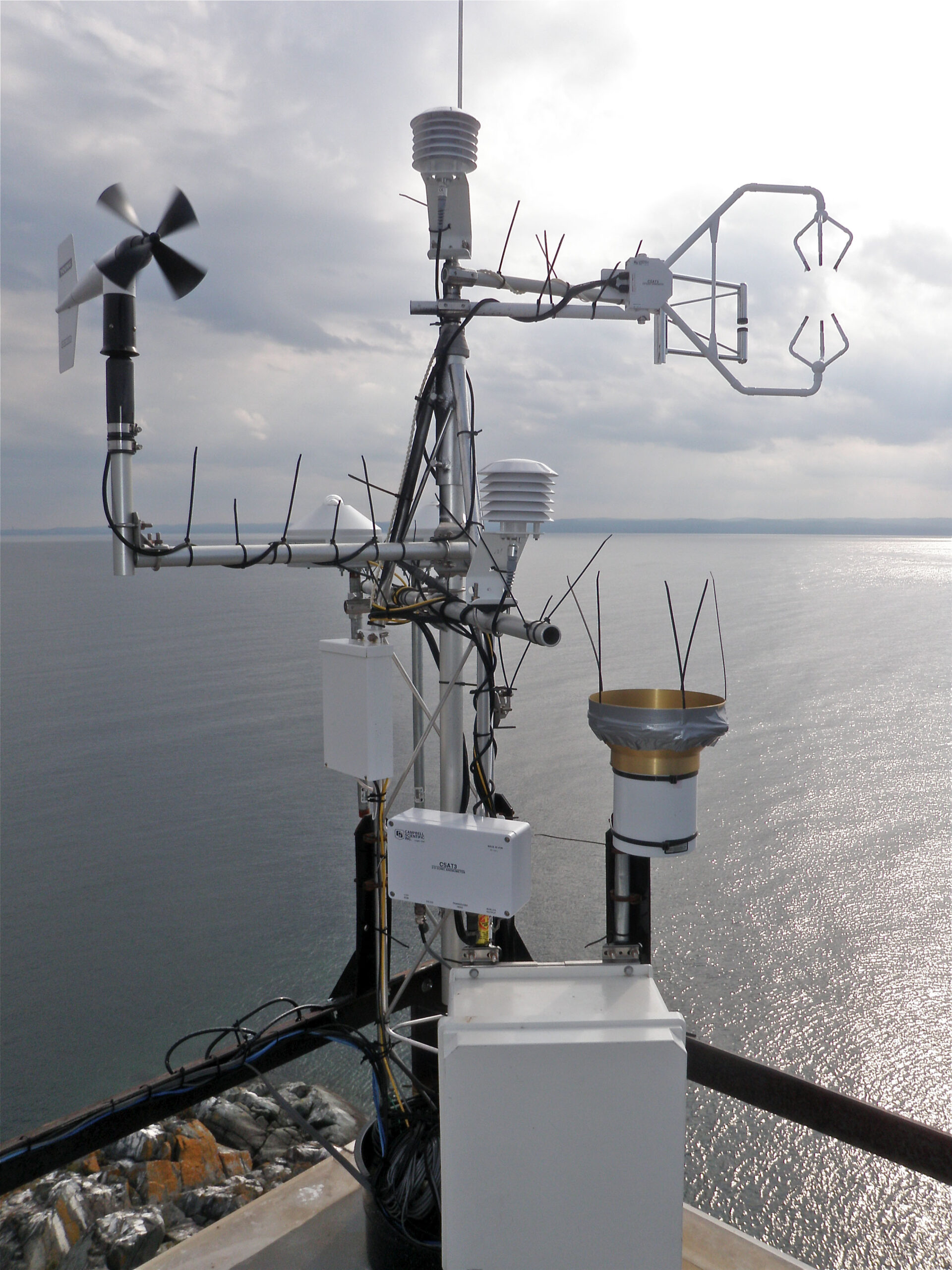 A weather station on Granite Island, Lake Superior. This weather station is part of a five-site network to measure year-round Great Lakes evaporation. In addition to evaporation, the weather station measures air temperature, relative humidity, barometric pressure, carbon dioxide, wind speed and direction, precipitation, solar radiation, and water temperature. Image credit: John Lenters