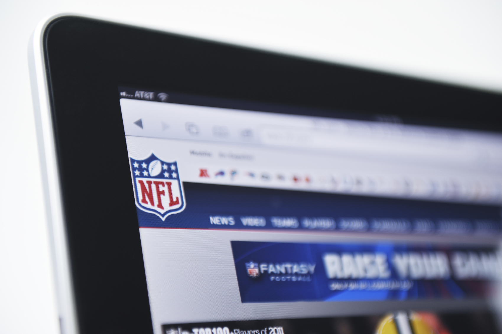 Holding an iPad Displaying the NFL Logo and Fantasy Football website. (stock image) 