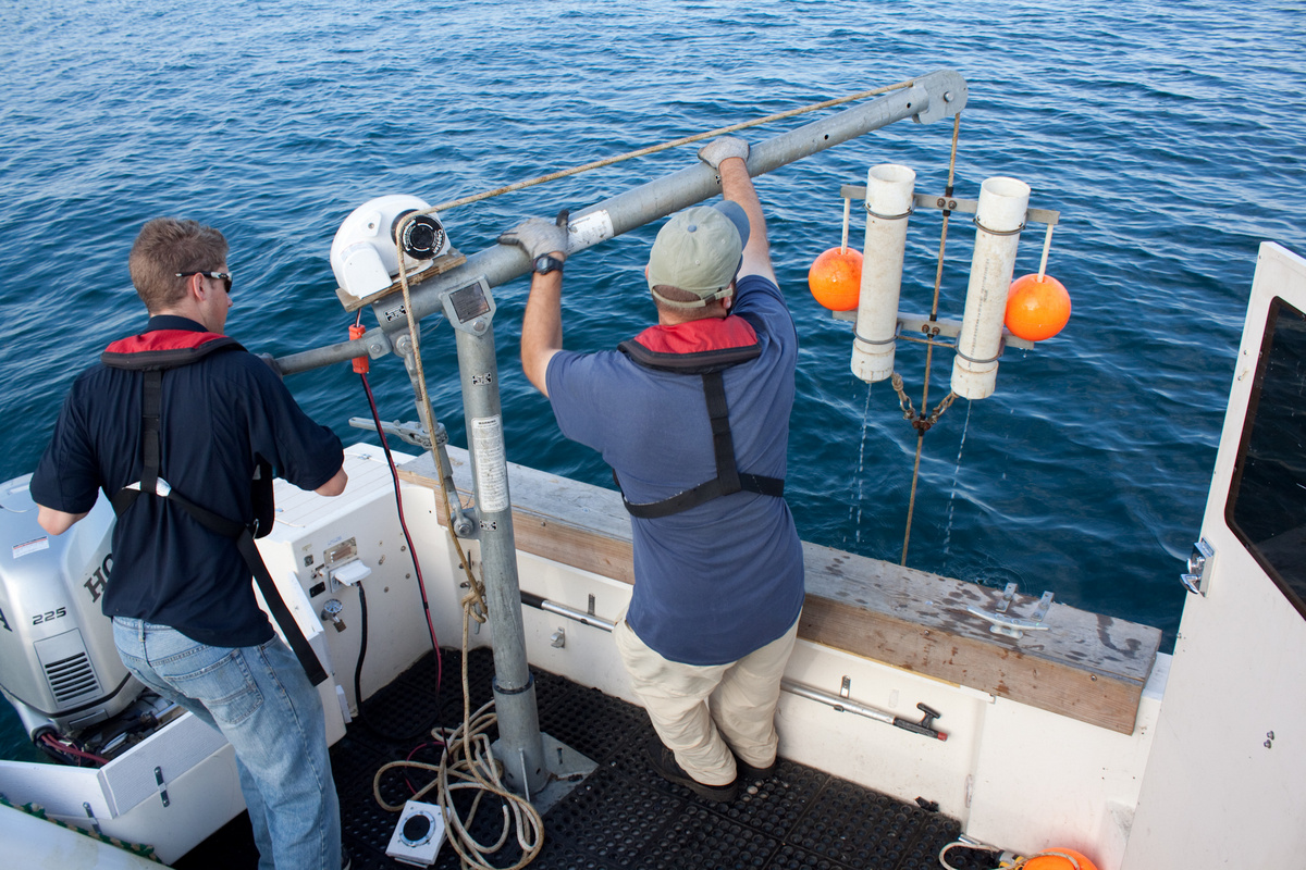 Researchers on Lake Erie retrieve a sediment trap that captures material settling through the water column. Image credit: Ed Verhamme