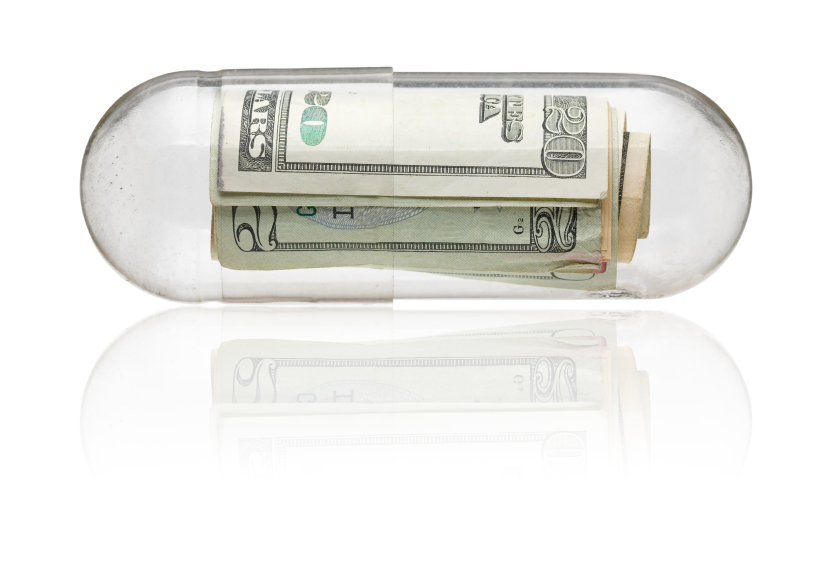 Several twenty-dollar bills rolled up and encased in a medication capsule. (stock image)