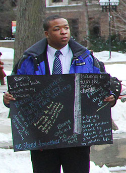 Student protester holds placard. Image by Adam Glanzman.