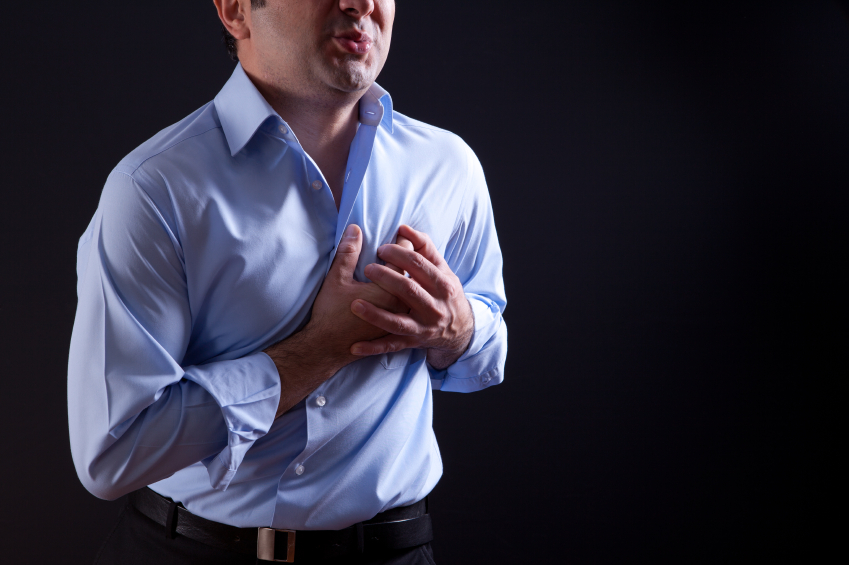 A man clutches his chest. (stock image)