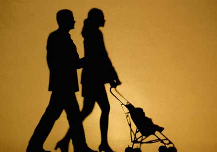 Silhouette of a couple walking with a baby stroller. (stock image)