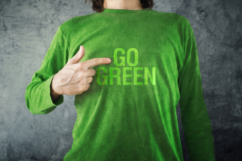 Go green. Man pointing to title printed on his shirt. (stock image)