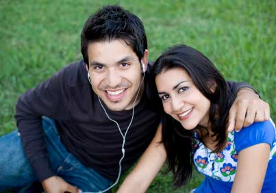 A happy couple smiles at the camera. (stock image)