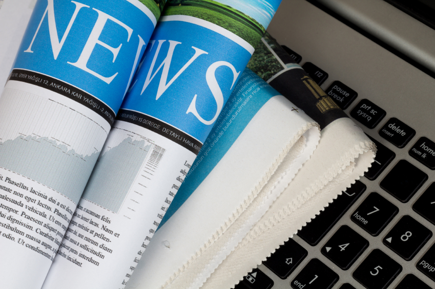 A stack of newspapers sits on a computer keyboard. (stock image)