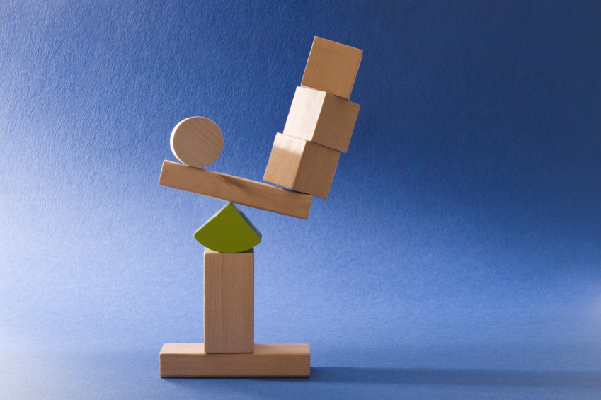 A stack of geometric wooden blocks out of balance. (stock image)